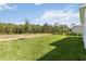 Spacious backyard with lush green lawn backing to the treeline at 9432 Emerald Berry Dr, Winter Garden, FL 34787