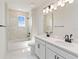 Elegant bathroom featuring double sinks, white marble tiling and black trim at 9432 Emerald Berry Dr, Winter Garden, FL 34787