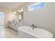 Bathroom features a freestanding tub, double sink vanity, and modern finishes at 9432 Emerald Berry Dr, Winter Garden, FL 34787