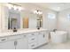 This bathroom features double sinks, sleek vanity, and a freestanding tub at 9432 Emerald Berry Dr, Winter Garden, FL 34787