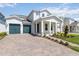 Beautiful home featuring a two-car garage, manicured lawn, and covered entryway with stone accents at 9432 Emerald Berry Dr, Winter Garden, FL 34787