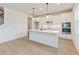 Modern kitchen with stainless appliances, white cabinetry, and a center island with pendant lighting at 9432 Emerald Berry Dr, Winter Garden, FL 34787