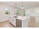 Bright kitchen features an island with a stainless steel dishwasher, sink, and modern pendant lighting at 9432 Emerald Berry Dr, Winter Garden, FL 34787