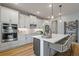 Modern kitchen with stainless steel appliances, a central island, and white cabinetry at 9432 Emerald Berry Dr, Winter Garden, FL 34787