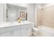 Bright bathroom with double vanity, framed mirror, and a combined bathtub and shower at 1104 Desert Candle Dr, Ocoee, FL 34761