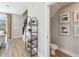 Bright entryway featuring decor shelving, a nearby half bathroom, and staircase at 1104 Desert Candle Dr, Ocoee, FL 34761