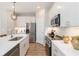 Modern kitchen featuring stainless steel appliances, white cabinetry and quartz countertops at 1104 Desert Candle Dr, Ocoee, FL 34761