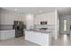 Modern eat-in kitchen with stainless appliances, white cabinetry, granite countertops, and tile flooring at 2465 Magnolia Reserve Rd, Ocoee, FL 34761