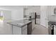 Open kitchen with a central island, stainless appliances, white cabinets, and tile flooring at 2465 Magnolia Reserve Rd, Ocoee, FL 34761