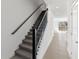 Staircase leading upstairs with gray carpet and a modern black railing and white wall at 2465 Magnolia Reserve Rd, Ocoee, FL 34761