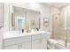 Modern bathroom features a double vanity, a large mirror, and tiled walk-in shower with glass doors at 2473 Magnolia Reserve Rd, Ocoee, FL 34761