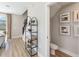 Entryway with decorative shelving, and view into powder room with modern art at 2473 Magnolia Reserve Rd, Ocoee, FL 34761