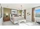 A main bedroom featuring large window, modern lighting fixture, and an accent wall at 2473 Magnolia Reserve Rd, Ocoee, FL 34761