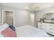 Bright bedroom featuring a walk-in closet, modern lighting fixture, and a stylish white dresser at 5228 Luisa Ct, St Cloud, FL 34771