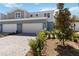 Charming townhome featuring a brick driveway, two-car garage, and manicured landscaping at 5228 Luisa Ct, St Cloud, FL 34771