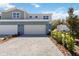 Charming townhome featuring a brick driveway, two-car garage, and manicured landscaping at 5228 Luisa Ct, St Cloud, FL 34771