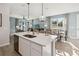 Bright kitchen features an island with pendant lighting, seating, and a dining area near large windows at 5228 Luisa Ct, St Cloud, FL 34771