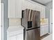 Close-up of kitchen featuring stainless steel refrigerator, white cabinets, and granite countertops at 5228 Luisa Ct, St Cloud, FL 34771