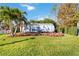 Airstream trailer on manicured lawn surrounded by flowers, a palm tree, and lush landscaping at 5289 Luisa Ct, St Cloud, FL 34771