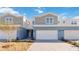 Charming townhome featuring a two-car garage, a light blue painted exterior, and manicured landscaping at 5289 Luisa Ct, St Cloud, FL 34771