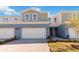 Charming townhome featuring a two-car garage, a light blue painted exterior, and manicured landscaping at 5289 Luisa Ct, St Cloud, FL 34771