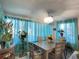 Dining room with modern chandelier, large windows with curtains and seating for six at 10867 Sw 83Rd Ct, Ocala, FL 34481