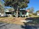 Charming single story home with light-green siding, manicured lawn, and mature shade tree in the front yard at 10867 Sw 83Rd Ct, Ocala, FL 34481