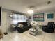 Living room with a dark sofa, decorative paintings, and tile floors at 10867 Sw 83Rd Ct, Ocala, FL 34481