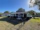 Backyard with view of an enclosed patio, lush landscaping, and a charming decorative fence at 10867 Sw 83Rd Ct, Ocala, FL 34481