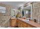 Bathroom with double sinks, wooden cabinets, neutral tiles and large mirrors at 3423 Publix Rd, Lakeland, FL 33810