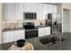 Well-lit kitchen featuring stainless steel appliances, granite counters, and white cabinetry at 5000 Balsam Falls Rd, Deland, FL 32724
