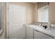 Functional laundry room with modern washer and dryer units, and a window for added light at 5000 Balsam Falls Rd, Deland, FL 32724