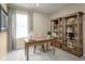 Dedicated home office space with natural light, wooden desk, and shelving for organized storage at 5000 Balsam Falls Rd, Deland, FL 32724