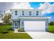 Charming two-story home featuring blue siding, a two-car garage, and a well-manicured lawn at 5004 Bear Lake Loop, Deland, FL 32724
