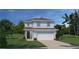 Charming two-story home with attached garage, landscaped yard and tropical foliage at 5035 Bear Lake Loop, Deland, FL 32724