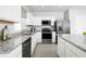 Modern kitchen featuring stainless steel appliances, granite countertops, and sleek white cabinetry at 1573 Texas Ave, Sumterville, FL 33585