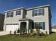 Two-story home featuring a two-car garage, and a well-manicured lawn at 1707 Jindo Dr, Lake Alfred, FL 33850