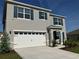 Two-story home featuring a two-car garage, and a well-manicured lawn at 1707 Jindo Dr, Lake Alfred, FL 33850