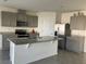 A modern kitchen featuring gray cabinets, stainless steel appliances, and a large island with granite countertops at 1707 Jindo Dr, Lake Alfred, FL 33850