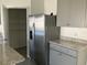 Open pantry next to stainless steel refrigerator, gray cabinets, and granite countertop at 1707 Jindo Dr, Lake Alfred, FL 33850