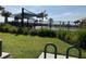 Scenic view of community pool area with palm trees, playground and shaded canopies at 1707 Jindo Dr, Lake Alfred, FL 33850