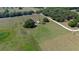 Serene aerial view of a beautiful property featuring lush green fields, scattered trees, and a cozy home at 3815 Se 25Th St, Bushnell, FL 33513