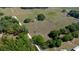 Acreage features cozy home featuring a sparkling pool amidst green fields and mature trees in this aerial view at 3815 Se 25Th St, Bushnell, FL 33513