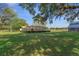 Large manicured backyard with a pool, barn, mature oak trees, and ample open space at 3815 Se 25Th St, Bushnell, FL 33513