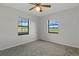 Bedroom with natural light from two windows overlooking green pastures, painted in neutral color at 3815 Se 25Th St, Bushnell, FL 33513