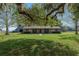 Well-maintained home with stone accents features a lush front lawn and mature tree, providing a welcoming curb appeal at 3815 Se 25Th St, Bushnell, FL 33513