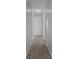 Hallway offers neutral colored walls, carpeted floor and entryways to multiple rooms at 3815 Se 25Th St, Bushnell, FL 33513