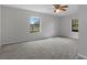 Bright, spacious main bedroom with neutral carpeting, two windows, and a ceiling fan at 3815 Se 25Th St, Bushnell, FL 33513