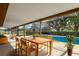 Outdoor patio area with a dining table, overlooking the sparkling pool and barn at 3815 Se 25Th St, Bushnell, FL 33513