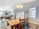 Bright dining room with wood floors, chandelier lighting, a table, chairs, and a view into the living room at 4649 Sw 103Rd Street Rd, Ocala, FL 34476
